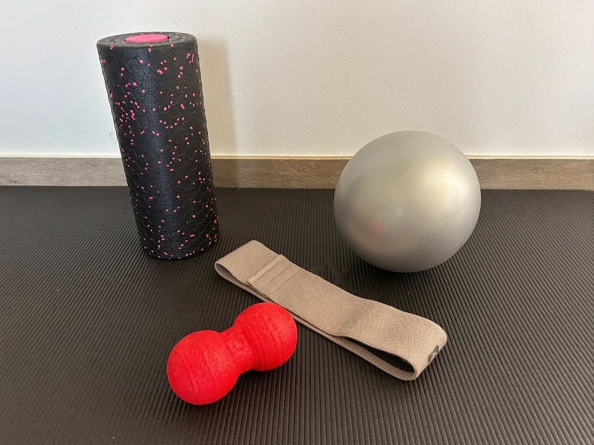 Übungsmaterial für die Krankengymnastik: Faszienrolle, Massageball, Widerstandsband und Pilatesball